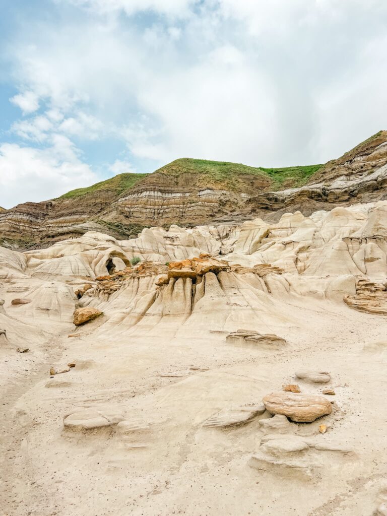 Badlands scenery in Drumheller. Small hoodoos are visible in the foreground, while there are coulees in the background.