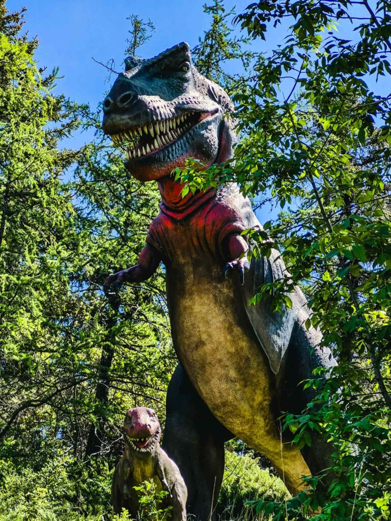 A giant mother T-Rex statue and a baby T-Rex statue at the Calgary Zoo.