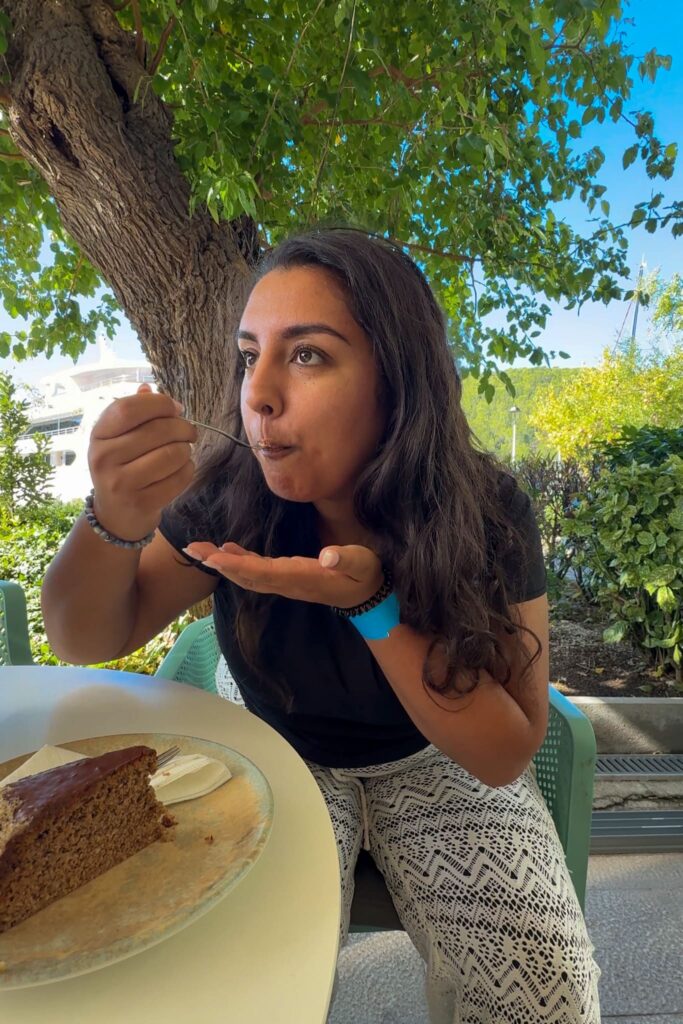 Alina with a fork of Skradin Cake in her mouth. There is a Skradin Cake on a plate in front of her.