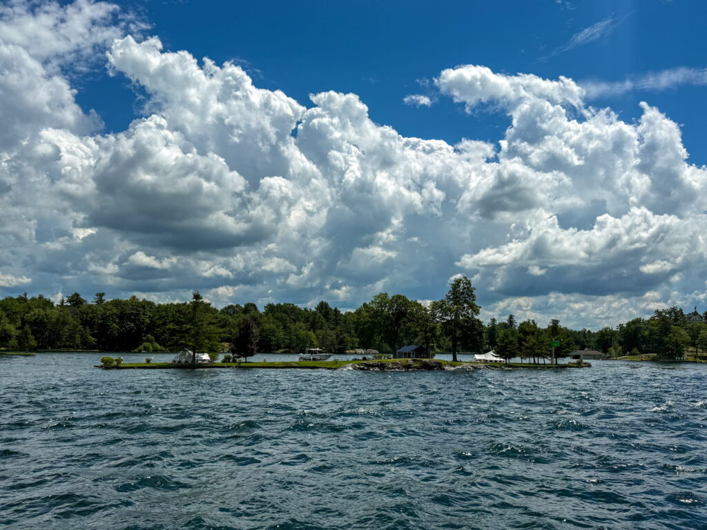 A small island in the 1000 Islands with a few trees and structures.