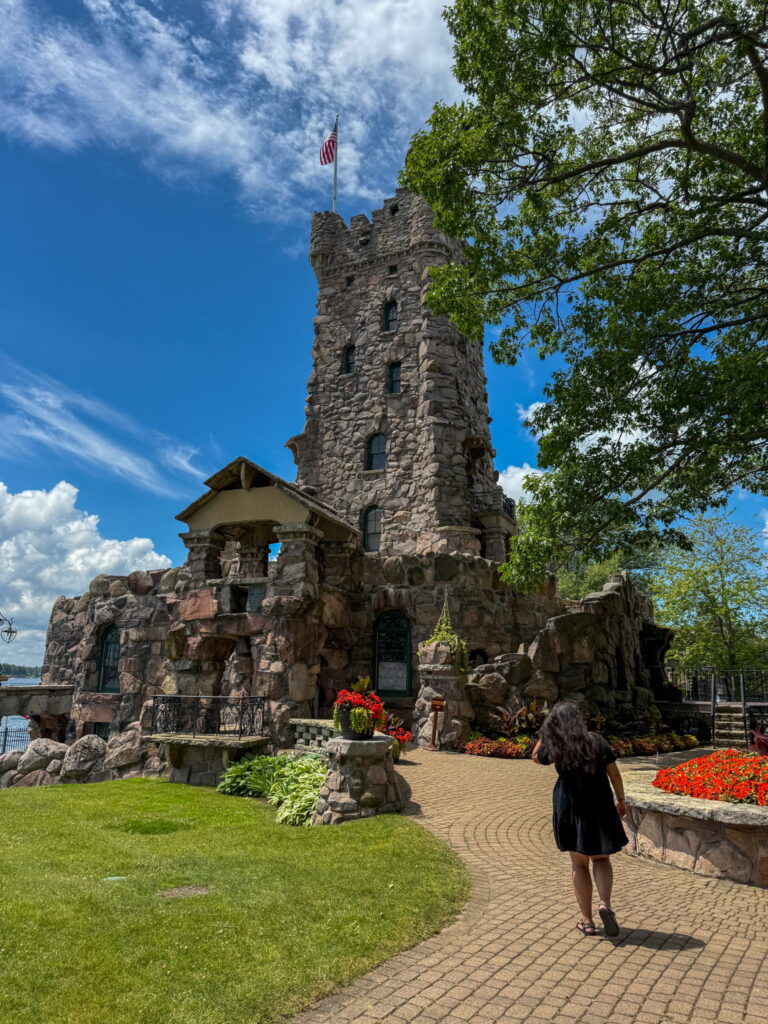 Alina walking towards Alster Tower on Heart Island. It looks like an stone medieval tower.