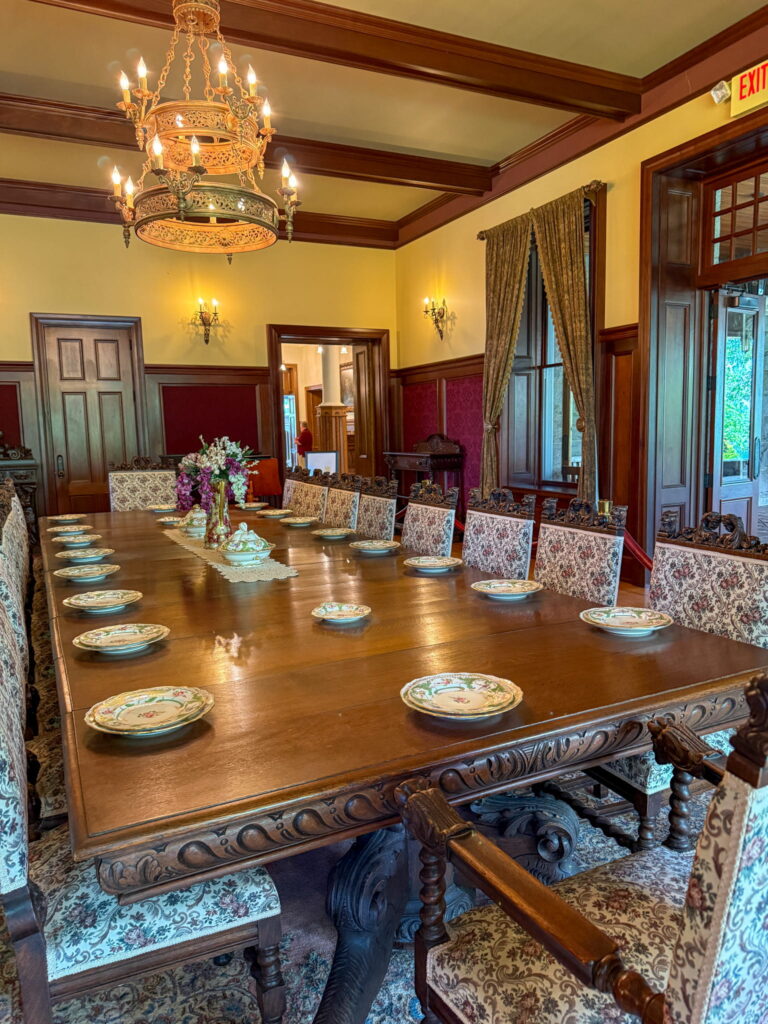 Boldt Castle's dining room. There are many ornate chairs and china and a hanging chandelier.